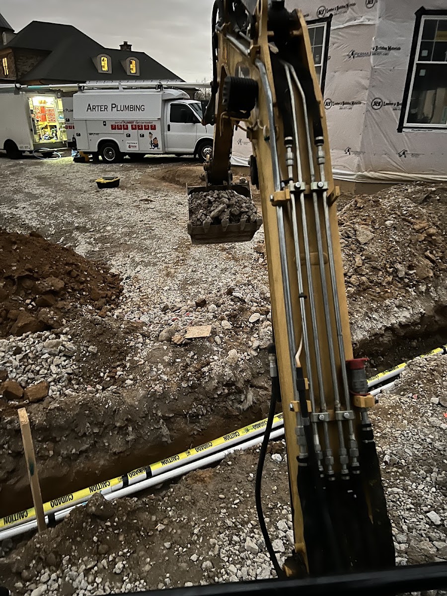 Arter Plumbing crew excavating a new water and sewer line at a Louisville home, branded company truck parked behind